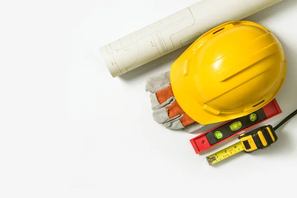 Blueprint Yellow safety helmet for construction and tools of construction workers preparing to work on time on white background.