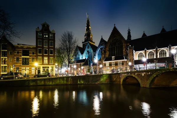 The Oude Church and a canal at night, in Amsterdam, The Netherlands — стоковое фото