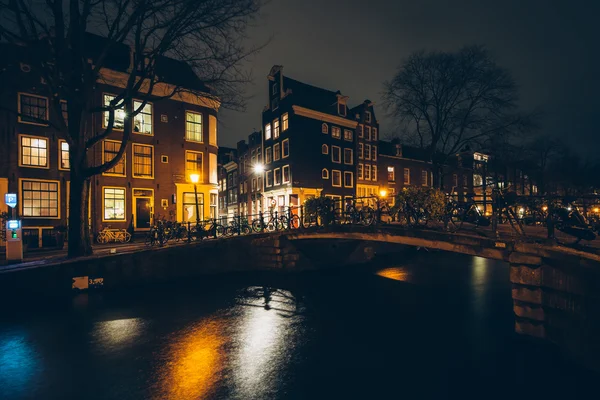 Most přes kanál v noci, v Amsterdamu, Nizozemsko. — Stock fotografie