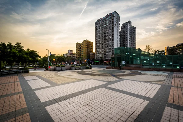 Parque e edifícios ao pôr do sol em Banqiao, em New Taipei City, Tai — Fotografia de Stock