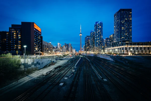 Vista de um pátio ferroviário e edifícios modernos no centro da cidade à noite, f — Fotografia de Stock