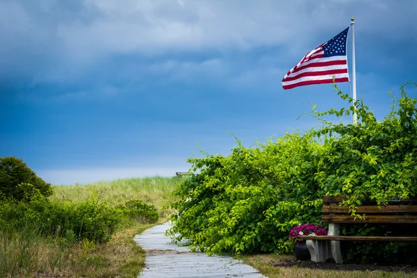 Bankjes en Amerikaanse vlag langs een wandelpad naar het strand in Seabro — Stockfoto