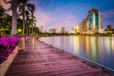 Modern gökdelenler, çiçek ve palmiye ağaçları Lake Rajada boyunca