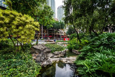 Garden and skyscrapers at Greenbelt Park, in Ayala, Makati, Metr clipart