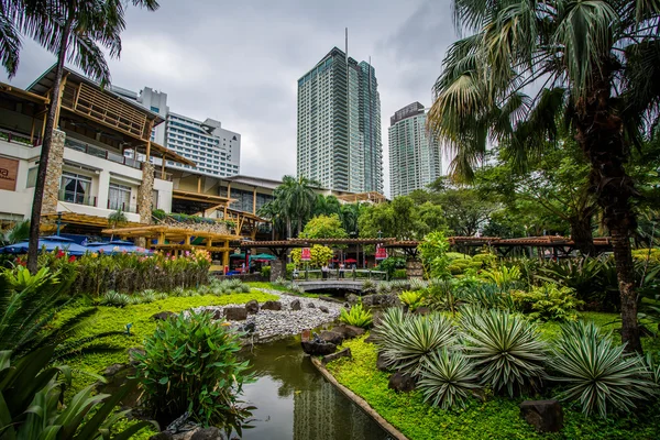 Jardins e arranha-céus em Greenbelt Park, em Ayala, Makati, Met — Fotografia de Stock