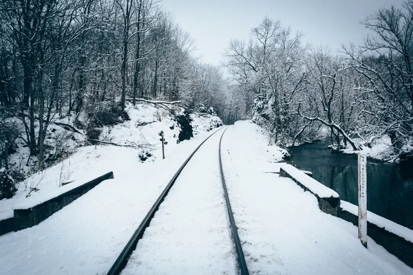 Une voie ferrée enneigée et un ruisseau dans le comté rural de Carroll , — Photo
