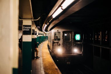 6 numaralı tren Astor Place metro istasyonundan kalkıyor. Manhattan, New York 'taki East Village' da.