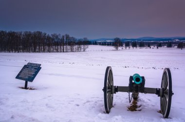 Cannon in a snow-covered field in Gettysburg, Pennsylvania.  clipart