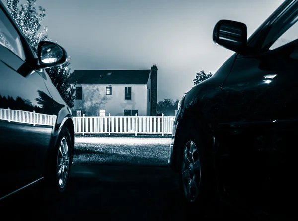 Uma casa entre dois carros, à noite . — Fotografia de Stock