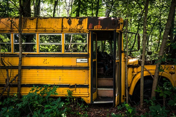 Ein rostiger alter Schulbus auf einem Schrottplatz. — Stockfoto