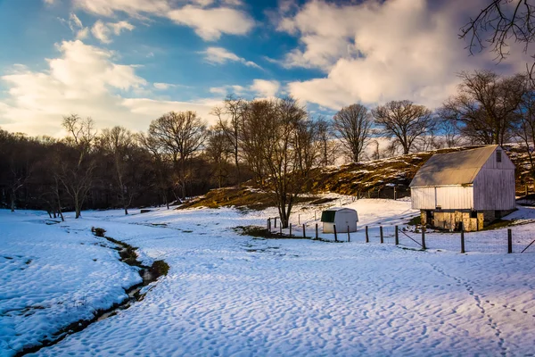 Ladan och snötäckta fältet på landsbygden baltimore county, maryland. — Stockfoto