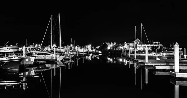 Boats and docks reflecting in the water at night, at a marina on — Stock Photo, Image