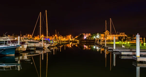 Barcos y muelles que se reflejan en el agua por la noche, en un puerto deportivo en — Foto de Stock