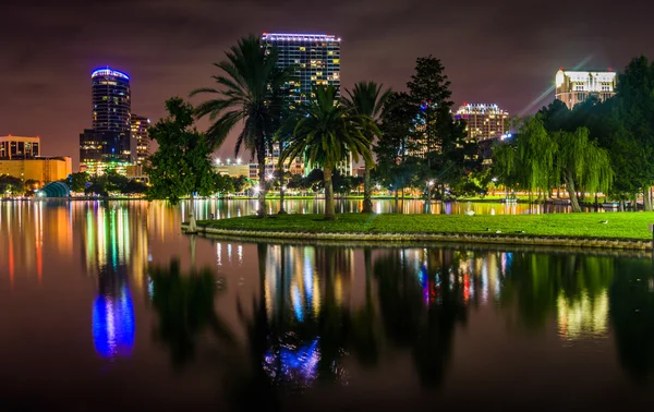 Edificios y palmeras que reflejan en el lago Eola por la noche, Orlan — Foto de Stock