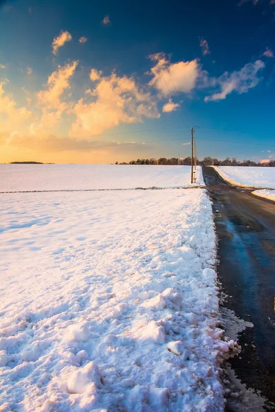 Venkovské silnici a sníh uvedených polí při západu slunce, ve venkovských york co — Stock fotografie