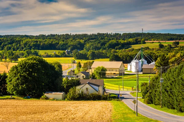 Country road and view of silo and barn on a farm in rural York C — Stock Photo, Image