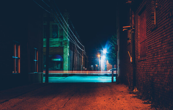Dark alley and light trails in Hanover, Pennsylvania at night. 
