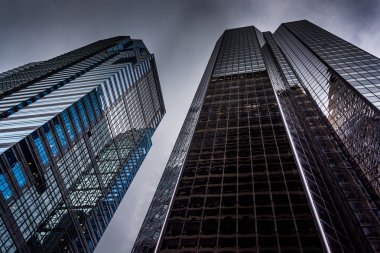 Looking up at modern buildings under a cloudy sky in Philadelphi clipart
