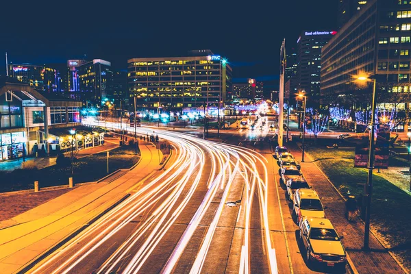 Long exposure of traffic moving past modern buildings on Pratt S