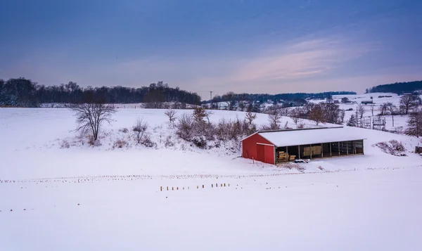 Röd lada på en snötäckt gård i landsbygdens york county, pennsylvan — Stockfoto