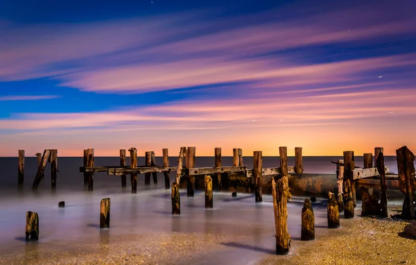 Ruinerna av en gammal brygga på sunset beach på natten, i Kap får nya — Stockfoto