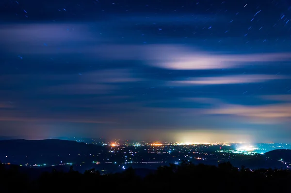 Le stelle e le nuvole si muovono attraverso il cielo notturno sopra le città nel Sh — Foto Stock