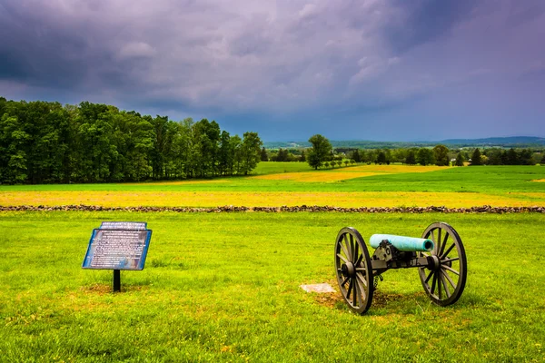 Gewitterwolken über einer Kanone und einem Schild auf einem Feld bei gettysburg, pe — Stockfoto