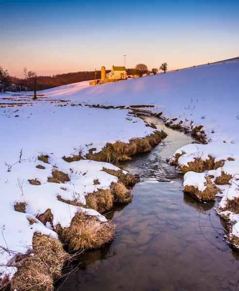 Stream and barn in a snow-covered farm field in eastern York Cou