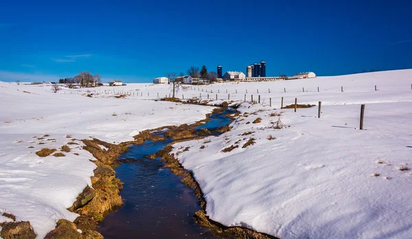 Corriente a través de un campo agrícola cubierto de nieve en Lancaster Coun rural —  Fotos de Stock