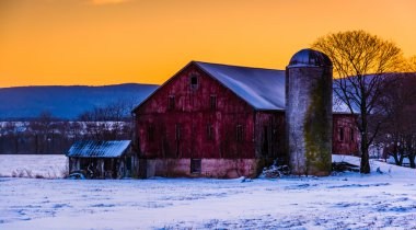 Winter sunset over a barn in rural Frederick County, Maryland.  clipart