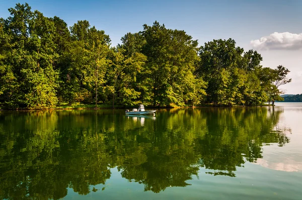 Bäume und Boot spiegeln sich im Loch Raven Reservoir, in der Nähe von Towson, — Stockfoto