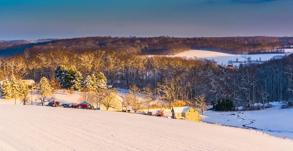 View of snow covered farm fields and rolling hills at sunset in — Stock Photo, Image