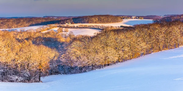 View of snow covered rolling hills and farm fields at sunset in — Stock Photo, Image