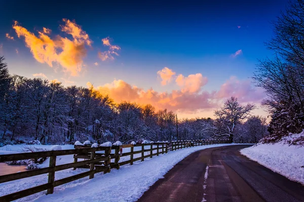 Puesta de sol invernal sobre una valla y una carretera rural en el condado rural de York — Foto de Stock