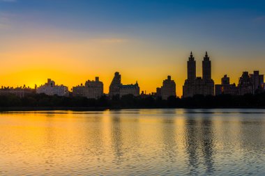 Sunset over Jacqueline Kennedy Onassis Reservoir and buildings i clipart