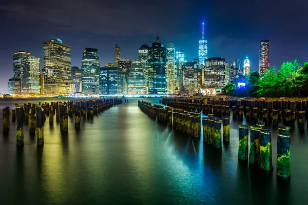 Pier palen en de skyline van manhattan's nachts, gezien vanaf brook — Stockfoto