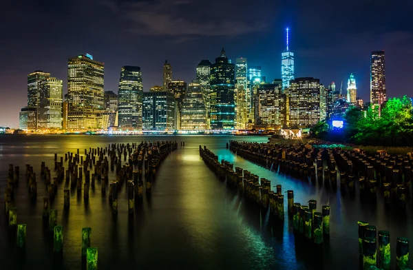 Molenpfähle und die Skyline von Manhattan bei Nacht, vom Bach aus gesehen — Stockfoto