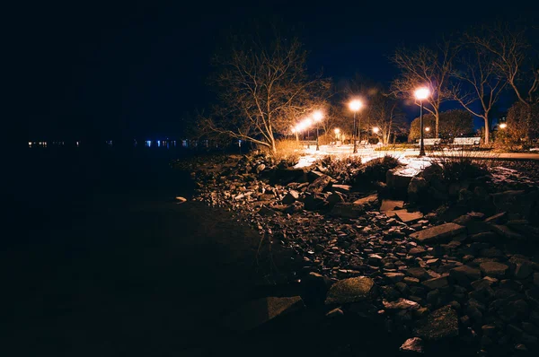 Lamps and rocks along the shore of the Chesapeake Bay at night, — Stock Photo, Image