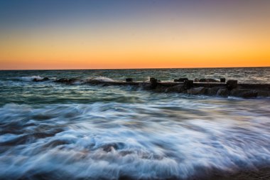 Dalgalar ve günbatımı bir iskeleye Edisto Beac, Atlantik Okyanusu