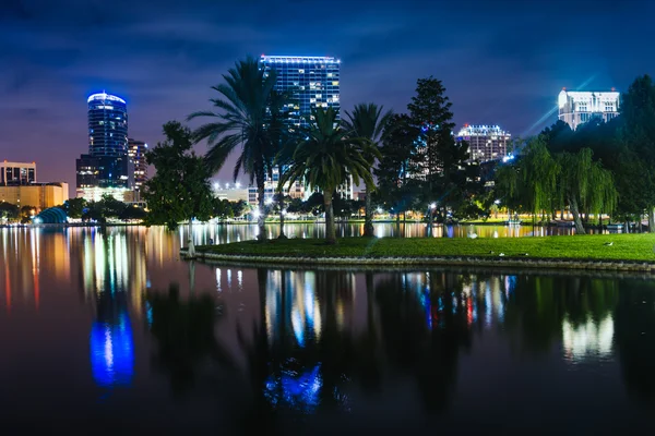 Edifícios e palmeiras refletindo em Lake Eola à noite, Orlan — Fotografia de Stock