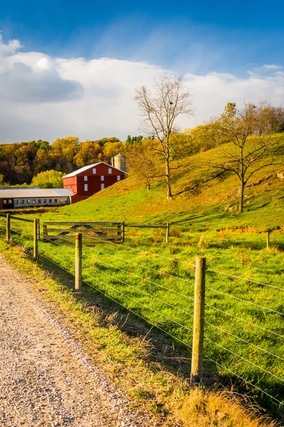 Celeiro vermelho ao longo da estrada rural no Condado de York, Pensilvânia . — Fotografia de Stock