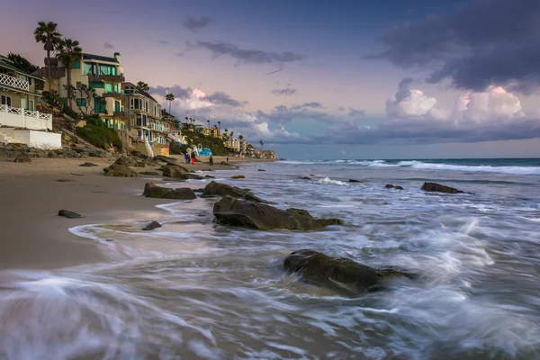 Onde che si infrangono su rocce e case fronte mare a Laguna Beach, Ca — Foto Stock