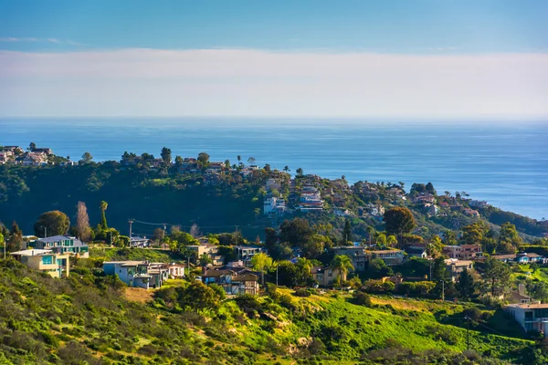 Weergave van groene heuvels en huizen met uitzicht op de Stille Oceaan, in — Stockfoto