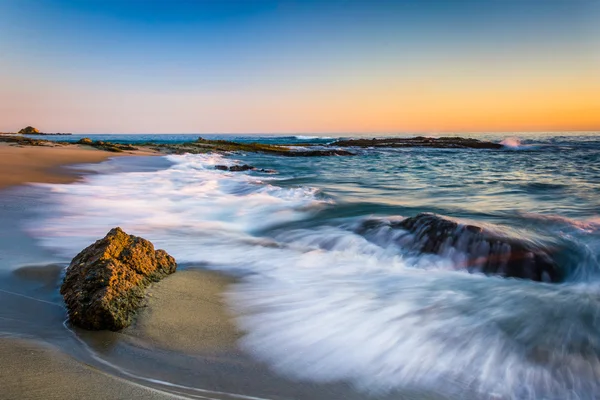 Κύματα που έσκαζαν στους βράχους, στο ηλιοβασίλεμα, στην παραλία Victoria, Laguna Bea — Φωτογραφία Αρχείου