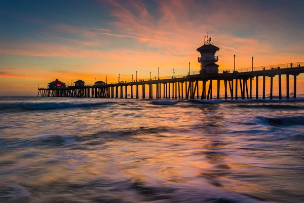 Olas en el Océano Pacífico y el muelle al atardecer, en Huntington — Foto de Stock