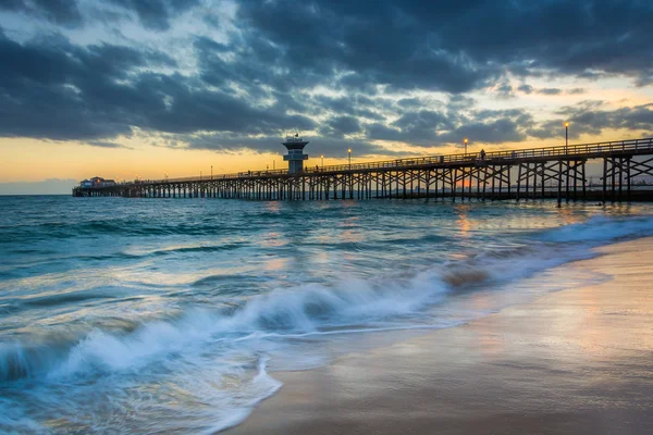 Fale w Ocean Spokojny i molo w zachód słońca, w Seal Beach — Zdjęcie stockowe