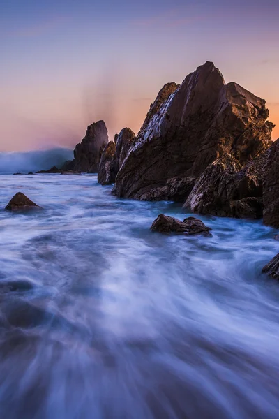 Wellen, die bei Sonnenuntergang auf Felsen krachen, in Corona del mar, Kalifornien — Stockfoto