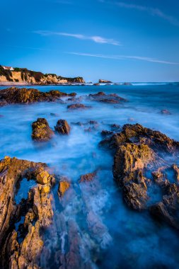 Kayalar ve küçük Corona Beach, Cor, alacakaranlıkta, gelgit havuzları