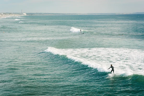 Oceanside, California Pasifik Okyanusu'nda bir dalga sürme sörfçü — Stok fotoğraf