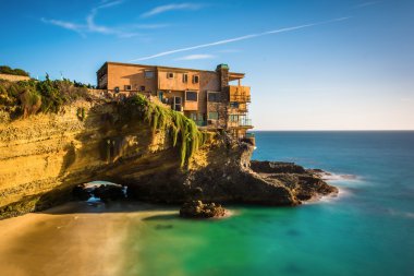 Long exposure of a house on a cliff and a small cove at Table Ro clipart